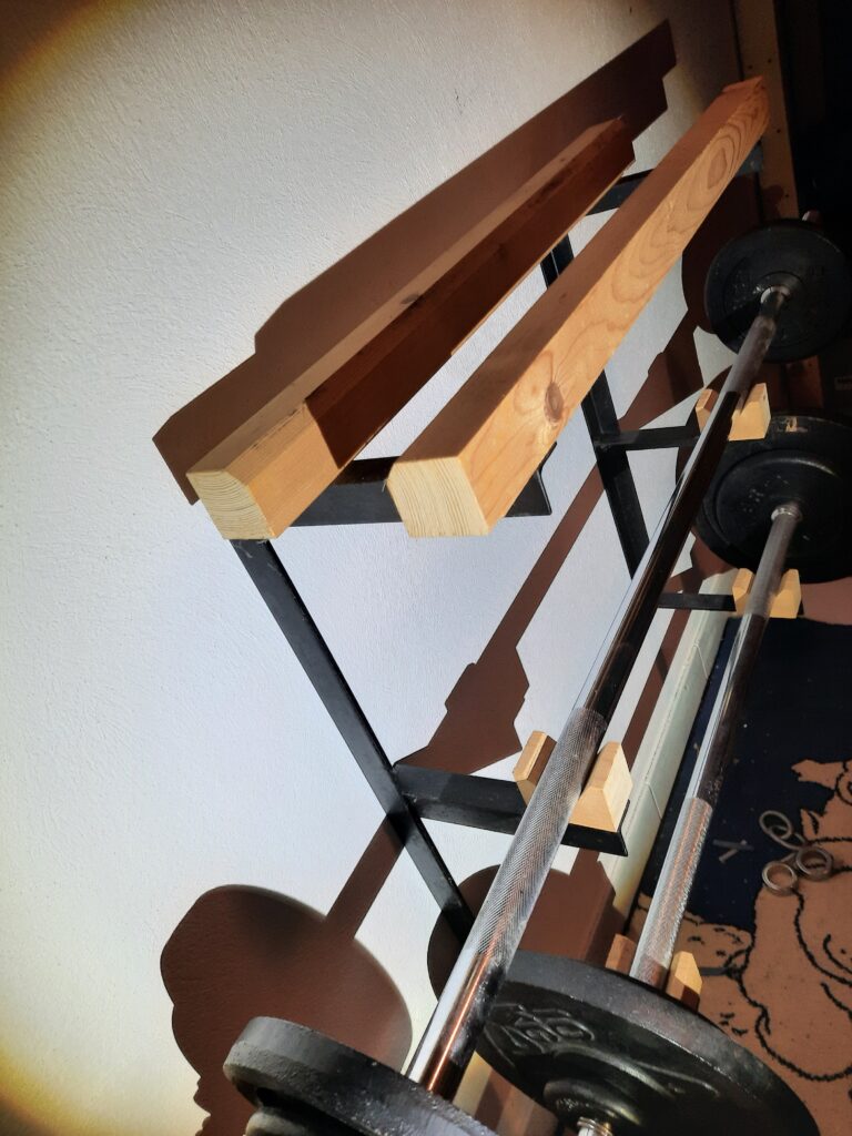 Lang- und Kurzhantel Ablage: Massive Ablage für die Wandmontage. Mit dekorativen und funktionellen Holzelementen schonend für verchromte Chromhantelstangen.