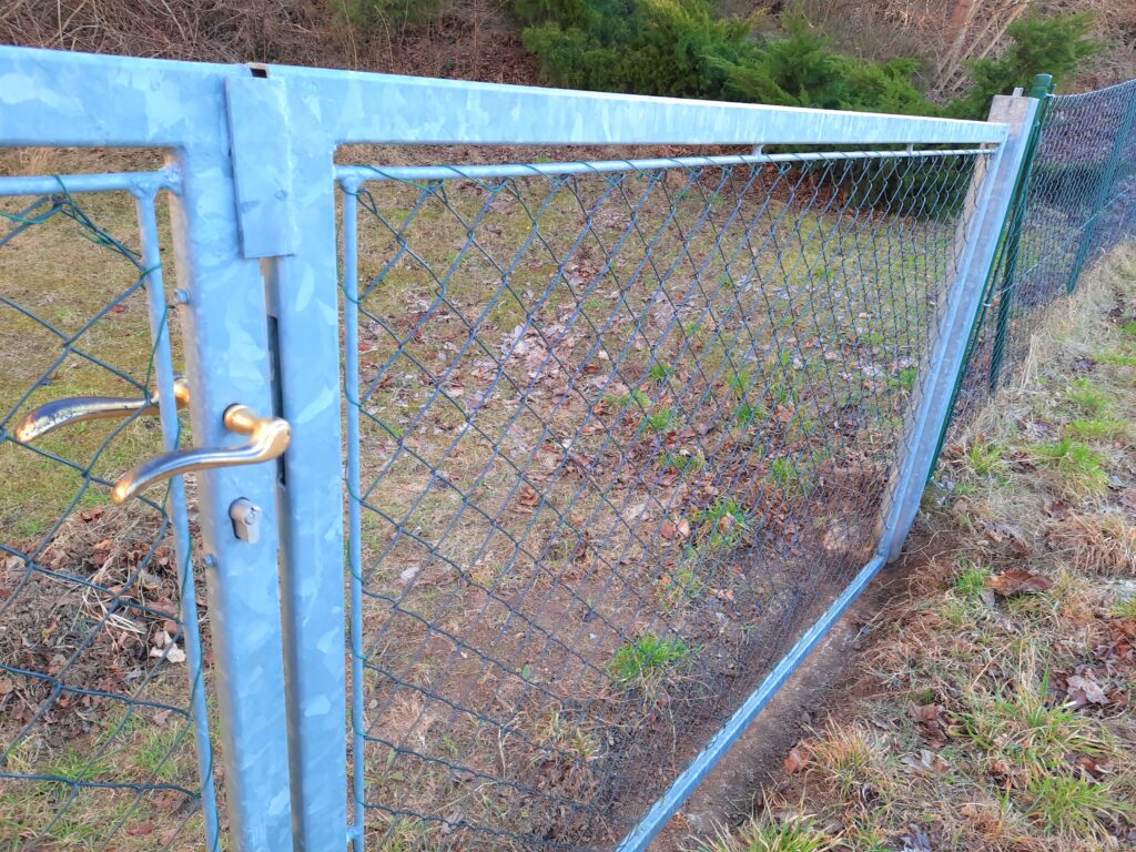 Zauntor verzinkt - Die Anforderung nach einer Durchfahrtsbreite von 480 cm erforderte eine robuste Ausführung mit Stehern 100x100mm und entsprechenden Bändern damit die Stabilität optimal gegeben ist und dennoch die Formschönheit und Schlichtheit überzeugt.